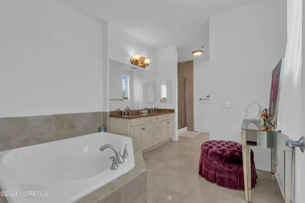 a bathroom with a tub sink and mirror