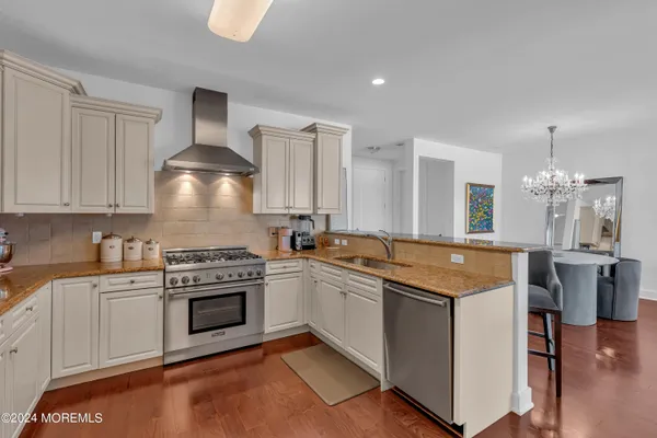 a kitchen with stainless steel appliances granite countertop a sink stove and refrigerator