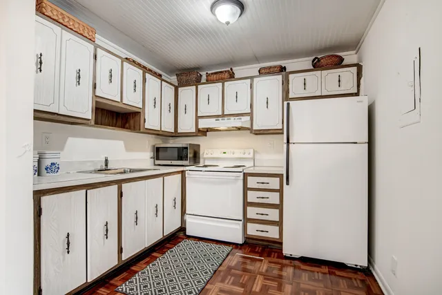 a kitchen with cabinets a refrigerator and a sink