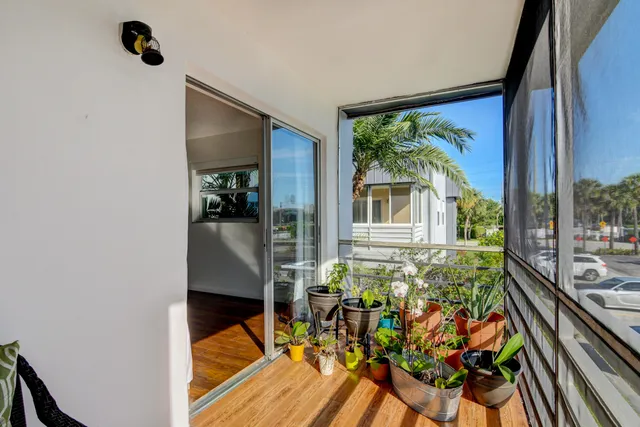 a view of a balcony with chairs and a potted plant