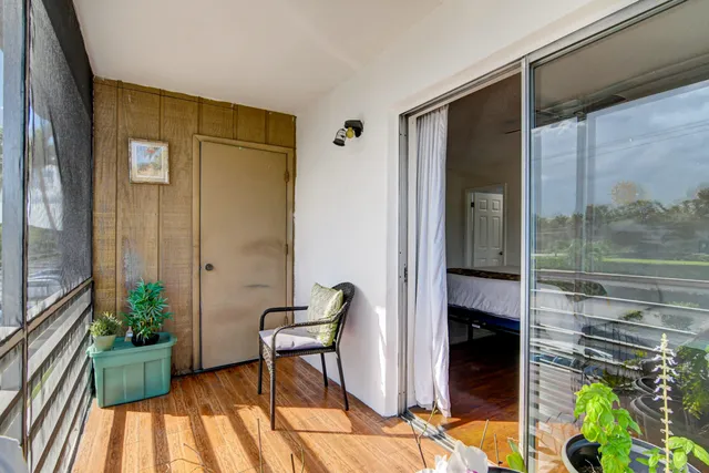 a patio with table and chairs and potted plants