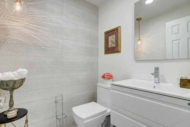 a bathroom with a sink a toilet and a mirror