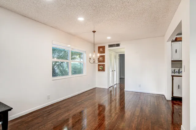 a view of a big room with wooden floor and windows
