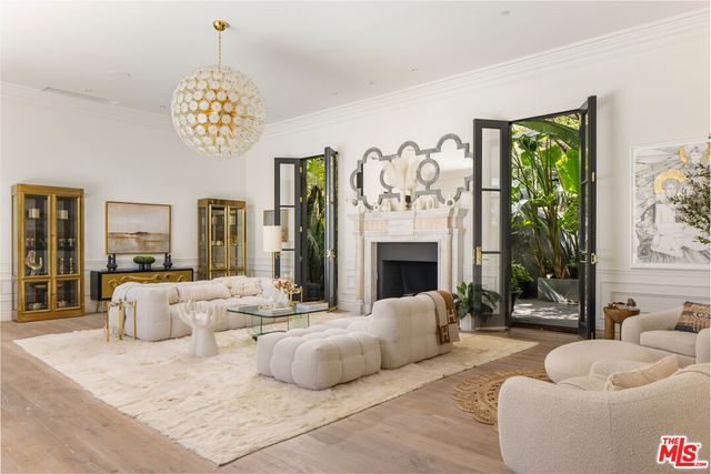 a spacious bedroom with a balcony a bed and a chandelier