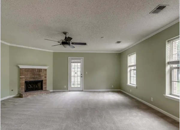 an empty room with fireplace and windows