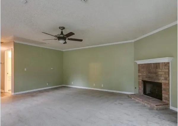an empty room with a ceiling fan and a fireplace