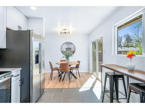 a dining room filled chandelier and wooden floor