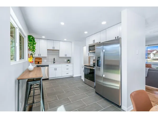 a kitchen with stainless steel appliances a refrigerator sink and cabinets