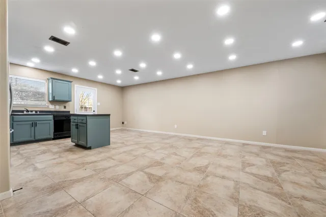 a large kitchen with a sink and cabinets