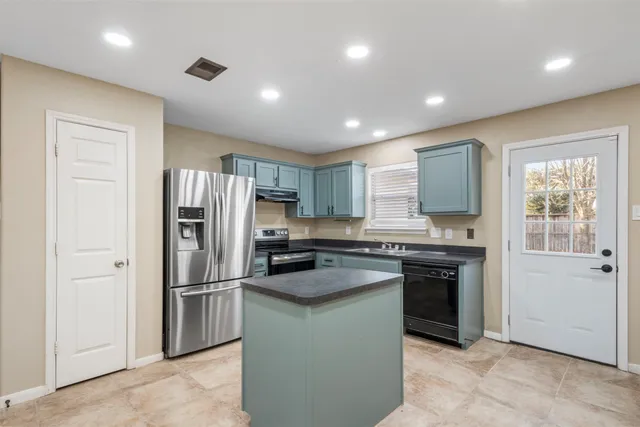 a kitchen with stainless steel appliances granite countertop a refrigerator sink and stove