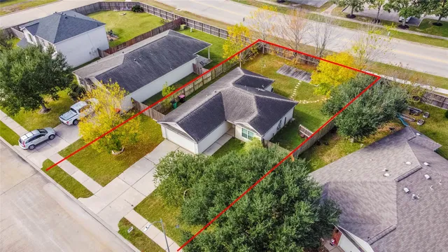 an aerial view of a house with a yard and swimming pool