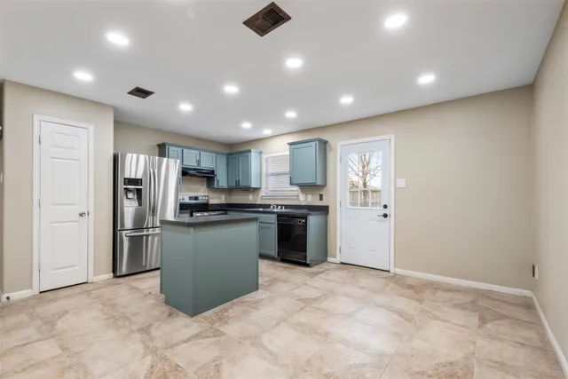 a kitchen with stainless steel appliances granite countertop a refrigerator and a sink