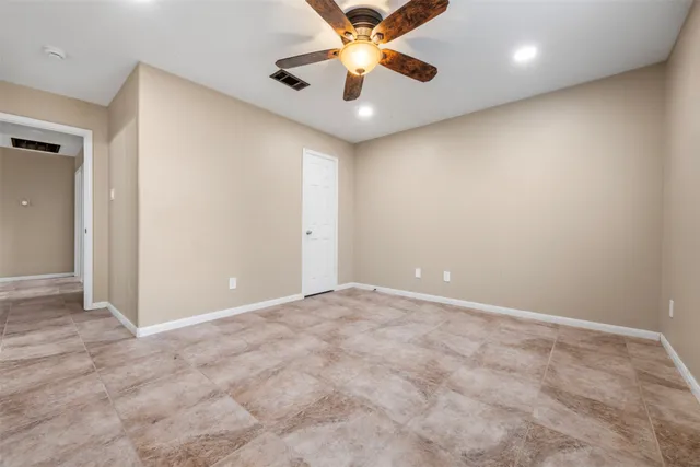 an empty room with a ceiling fan and a ceiling fan