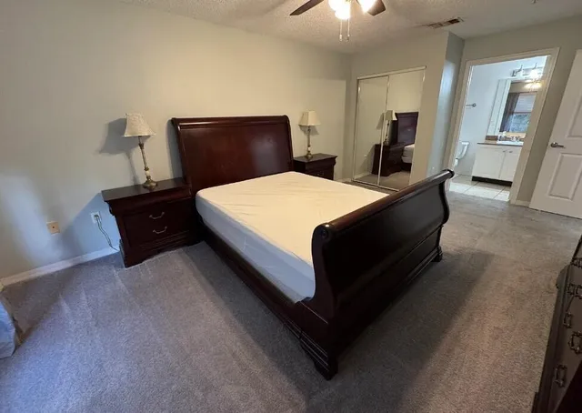 a bathroom with a granite countertop toilet sink and mirror