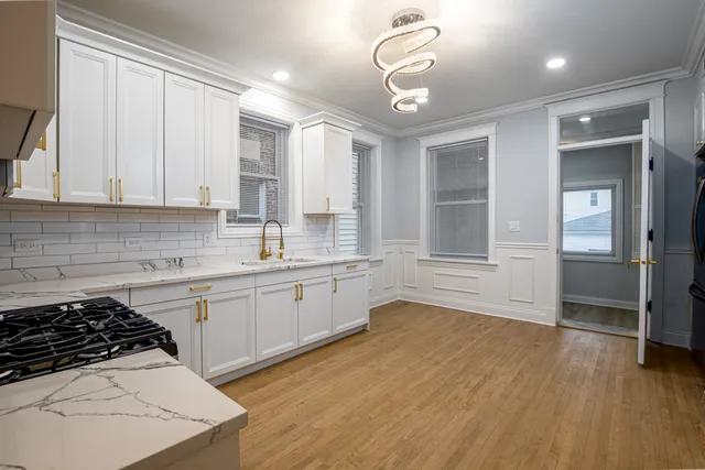 a kitchen with granite countertop a stove a sink and a refrigerator