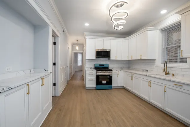 a kitchen with kitchen island granite countertop a sink cabinets and stainless steel appliances