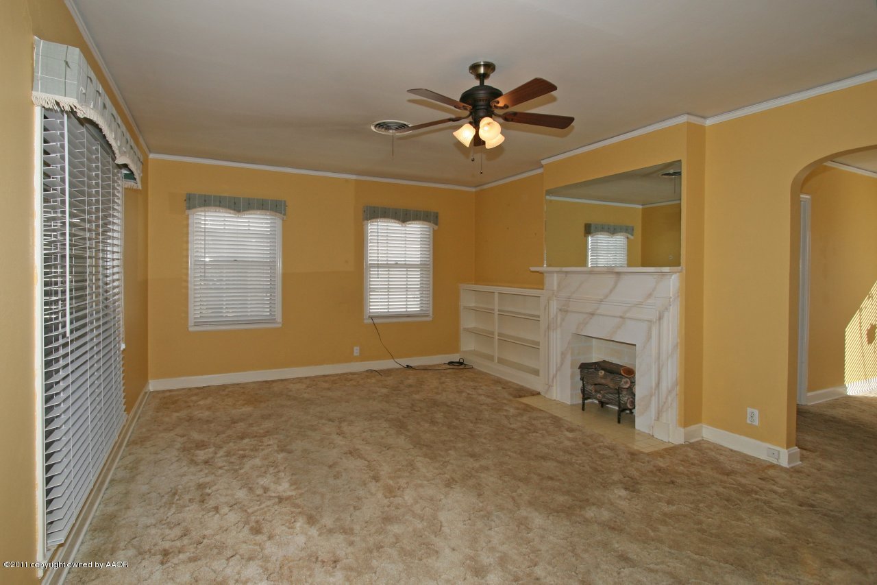 927 South Rusk Street Amarillo, TX 79102 - Photo 3 of 13 a view of an empty room with a fireplace and a window