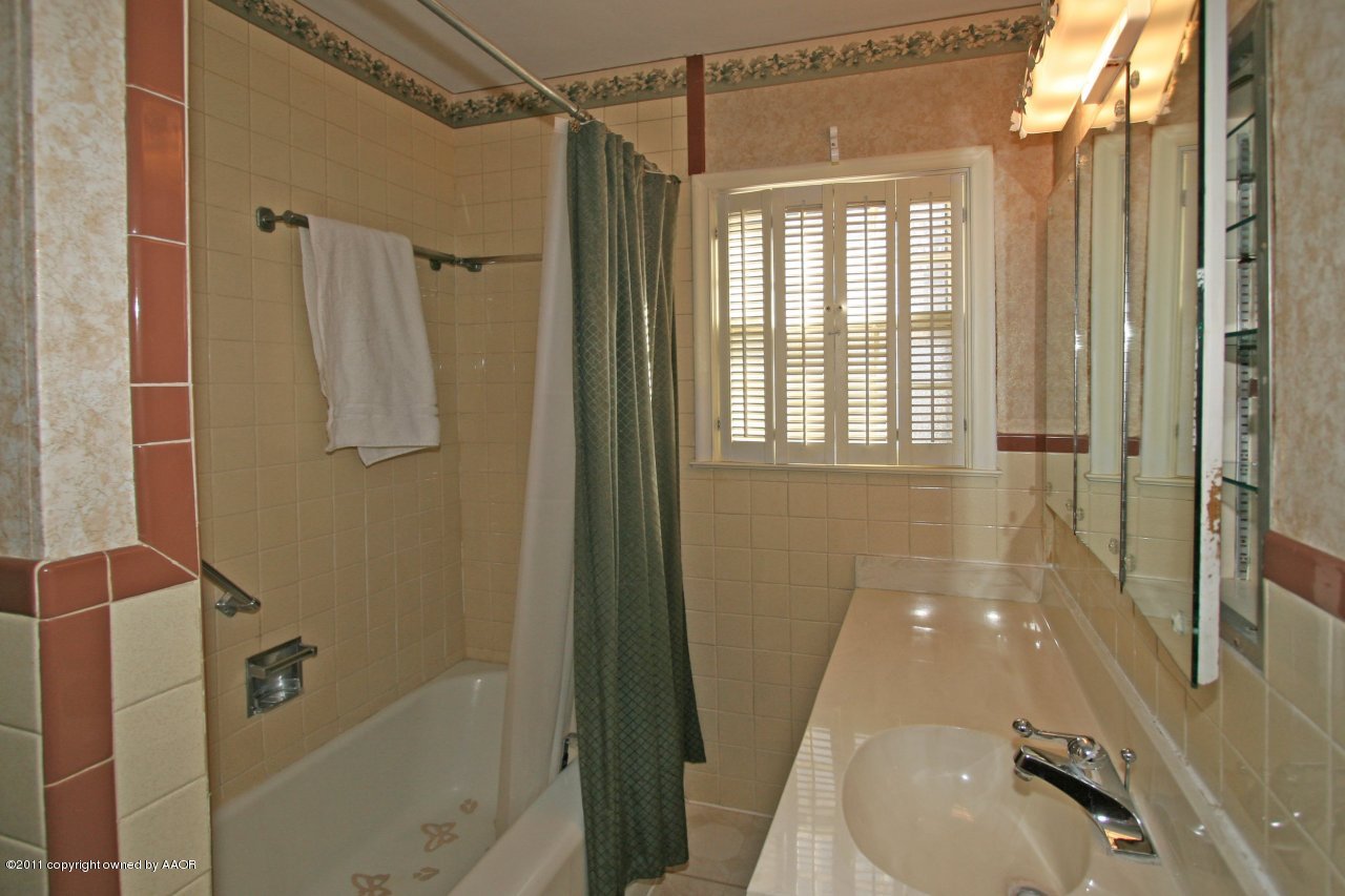 927 South Rusk Street Amarillo, TX 79102 - Photo 10 of 13 a bathroom with a granite countertop shower mirror and a sink