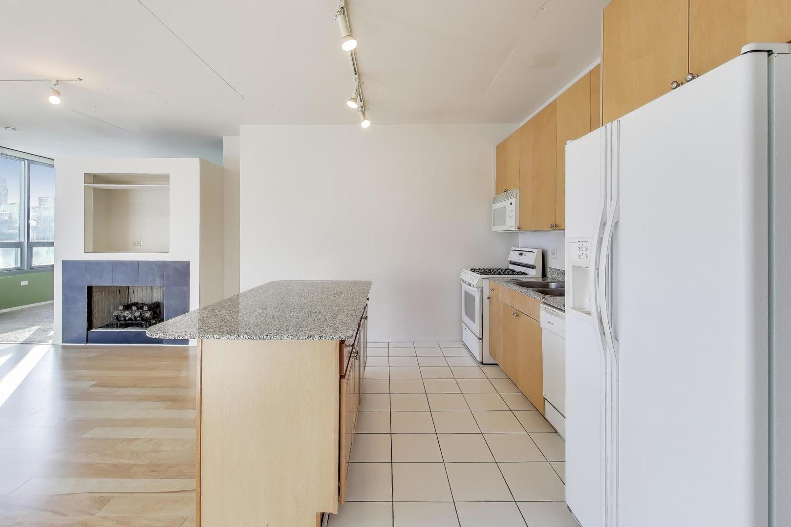 701 South Wells Street, Unit 1402 Chicago, IL 60607 - Photo 13 of 47 a kitchen with a refrigerator a stove top oven and cabinets