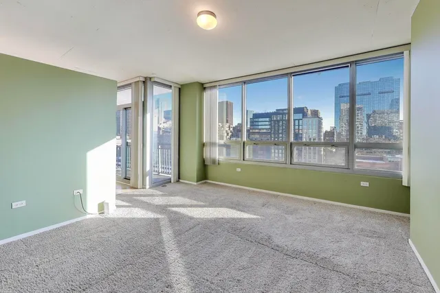 a view of an empty room with a fireplace and a ceiling fan
