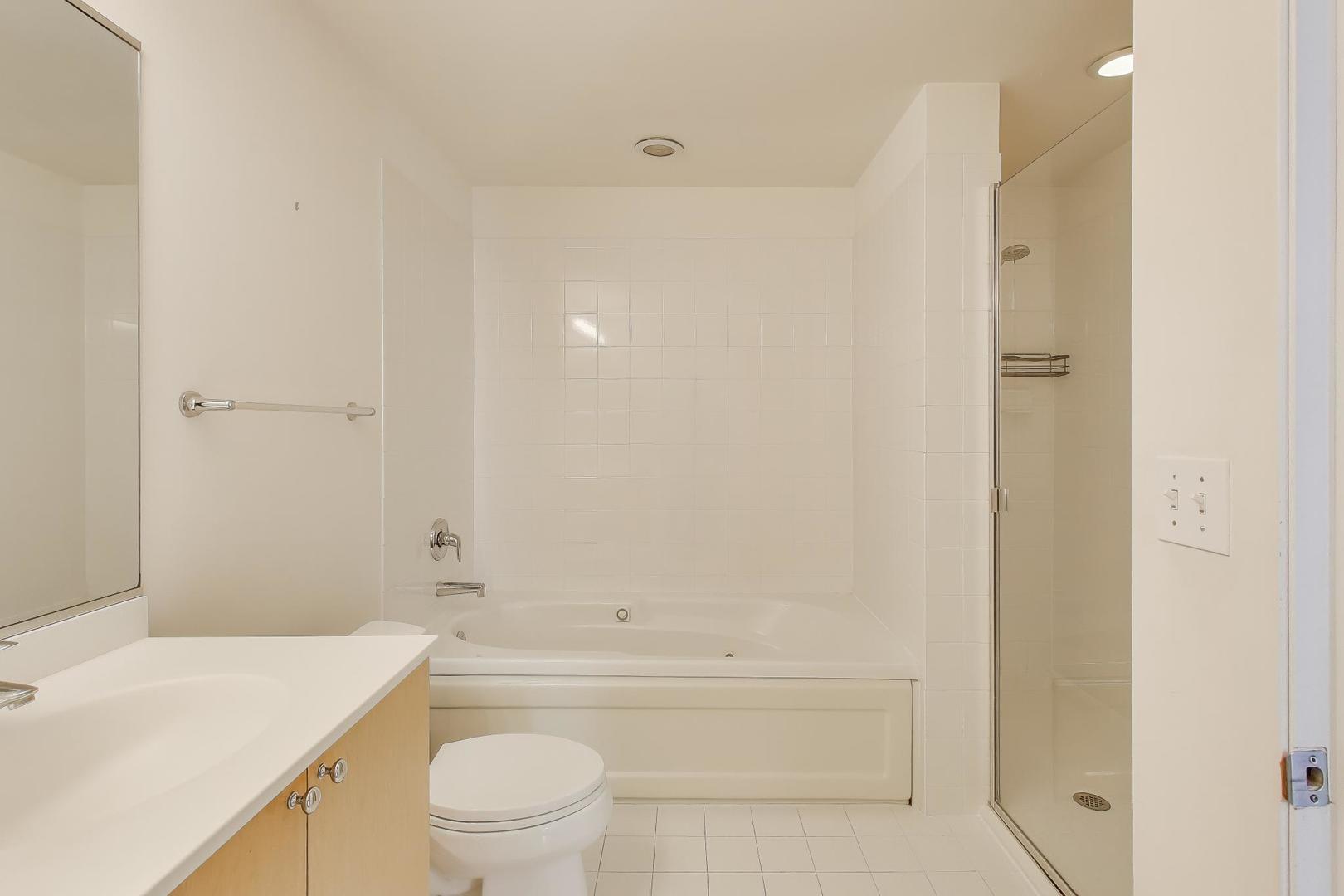 701 South Wells Street, Unit 1402 Chicago, IL 60607 - Photo 19 of 47 a bathroom with a bathtub shower sink vanity and toilet