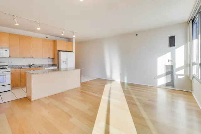 a view of empty room with wooden floor and window