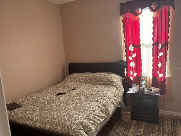 a bed sitting in a bedroom next to a lamp