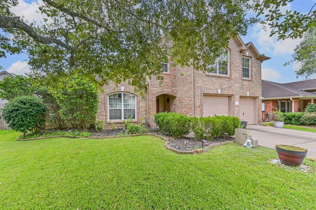 a front view of a house with a garden and yard