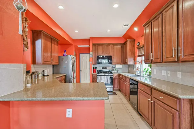 a kitchen with stainless steel appliances granite countertop a sink counter space cabinets and a large window