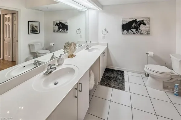 a bathroom with a double vanity sink mirror and toilet