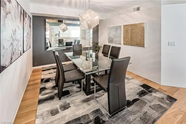 a view of a dining room with furniture a chandelier and wooden floor
