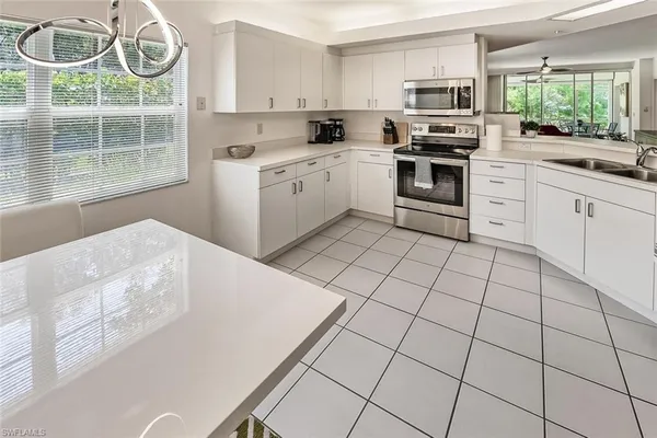 a kitchen with stainless steel appliances a stove a sink and white cabinets