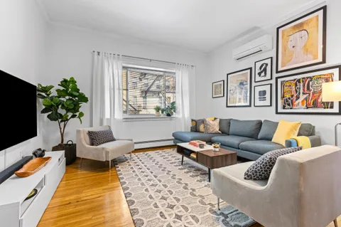 a living room with furniture plant and a flat screen tv
