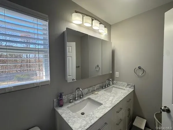 a bathroom with a granite countertop sink a mirror and a window