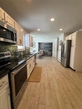 a kitchen with stainless steel appliances wooden cabinets a stove a microwave and a refrigerator