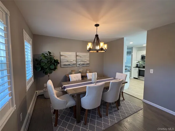 a view of a dining room with furniture a chandelier and wooden floor