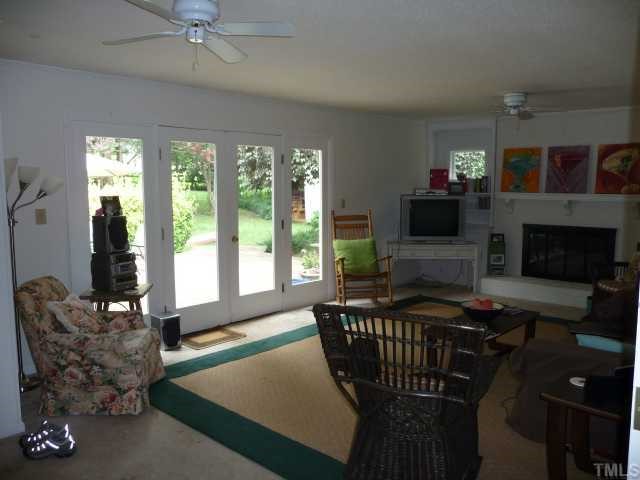 2711 Kittrell Drive Raleigh, NC 27608 - Photo 4 of 11 a living room with furniture a flat screen tv and a fireplace