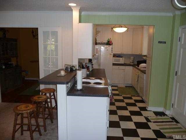 2711 Kittrell Drive Raleigh, NC 27608 - Photo 7 of 11 a kitchen with a refrigerator and a stove top oven