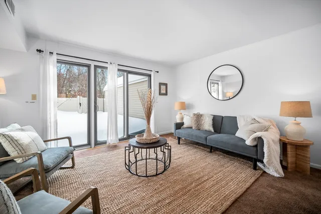 a living room with furniture a table and a large window