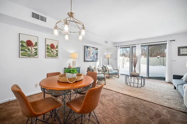 a dining room with furniture a painting and a chandelier