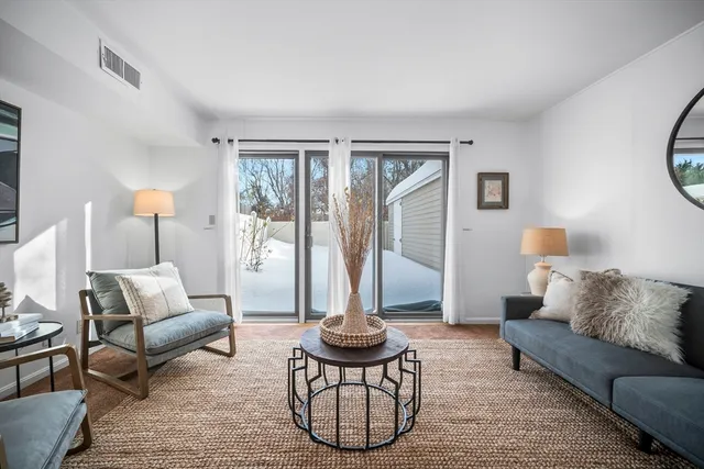 a living room with furniture a rug and a large window