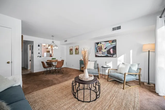 a living room with furniture a rug and a table