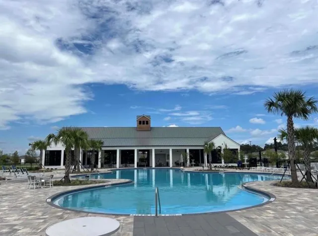 a view of a house with swimming pool and sitting area