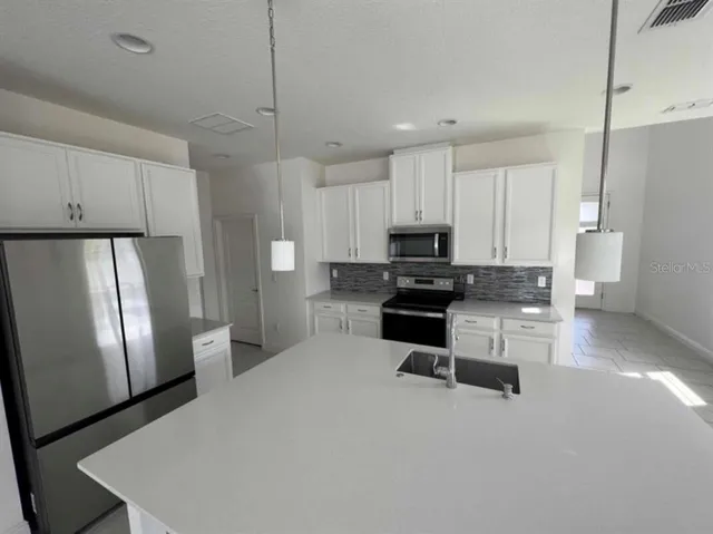 a kitchen with stainless steel appliances a refrigerator sink and stove
