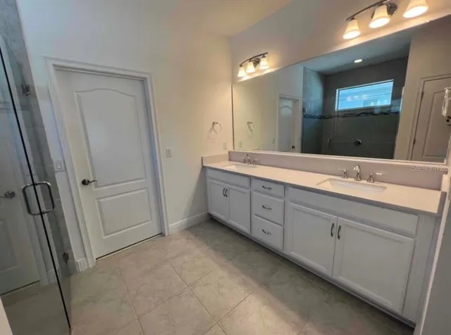 a bathroom with a double vanity sink and mirror