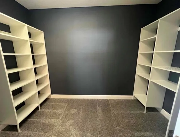 a view of bedroom with wooden floor and shelf