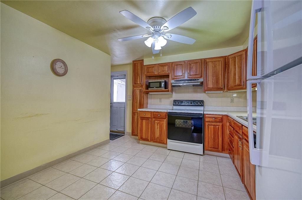 21 Spring Street Etna, PA 15223 - Photo 9 of 27 a kitchen with stainless steel appliances granite countertop a stove sink and cabinets