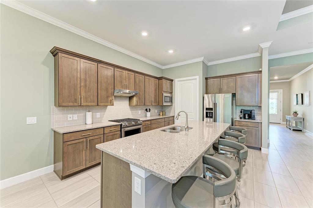17631 Colebrook Circle Lakewood Ranch, FL 34202 - Photo 23 of 85 a kitchen with a sink a stove a refrigerator cabinets and wooden floor