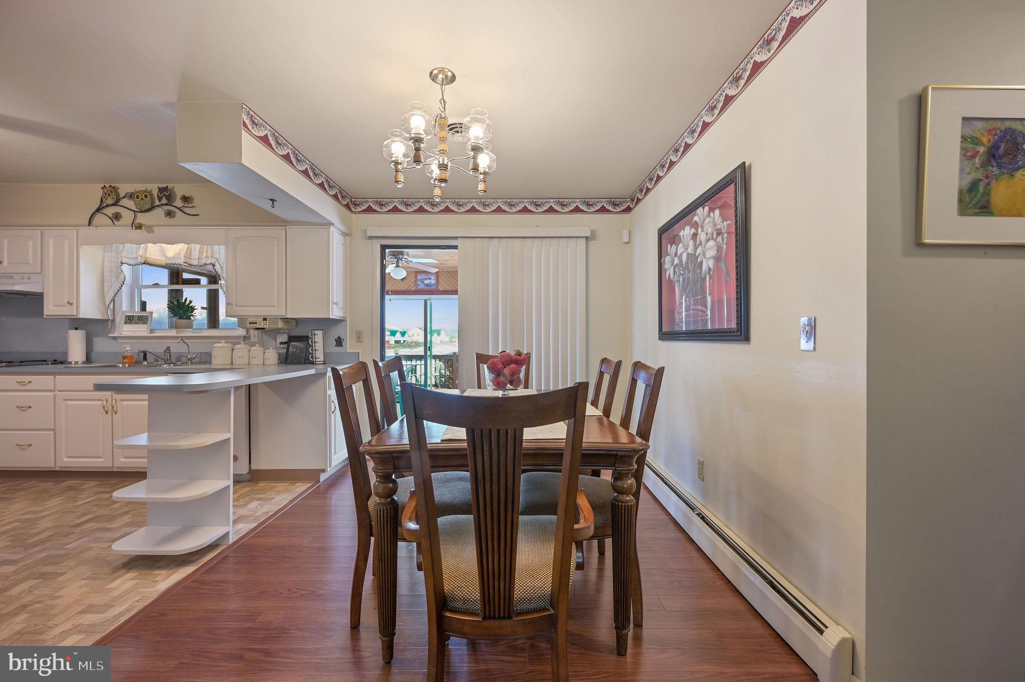4634 Kenton Road Dover, DE 19904 - Photo 12 of 34 a view of a dining room with furniture wooden floor and chandelier