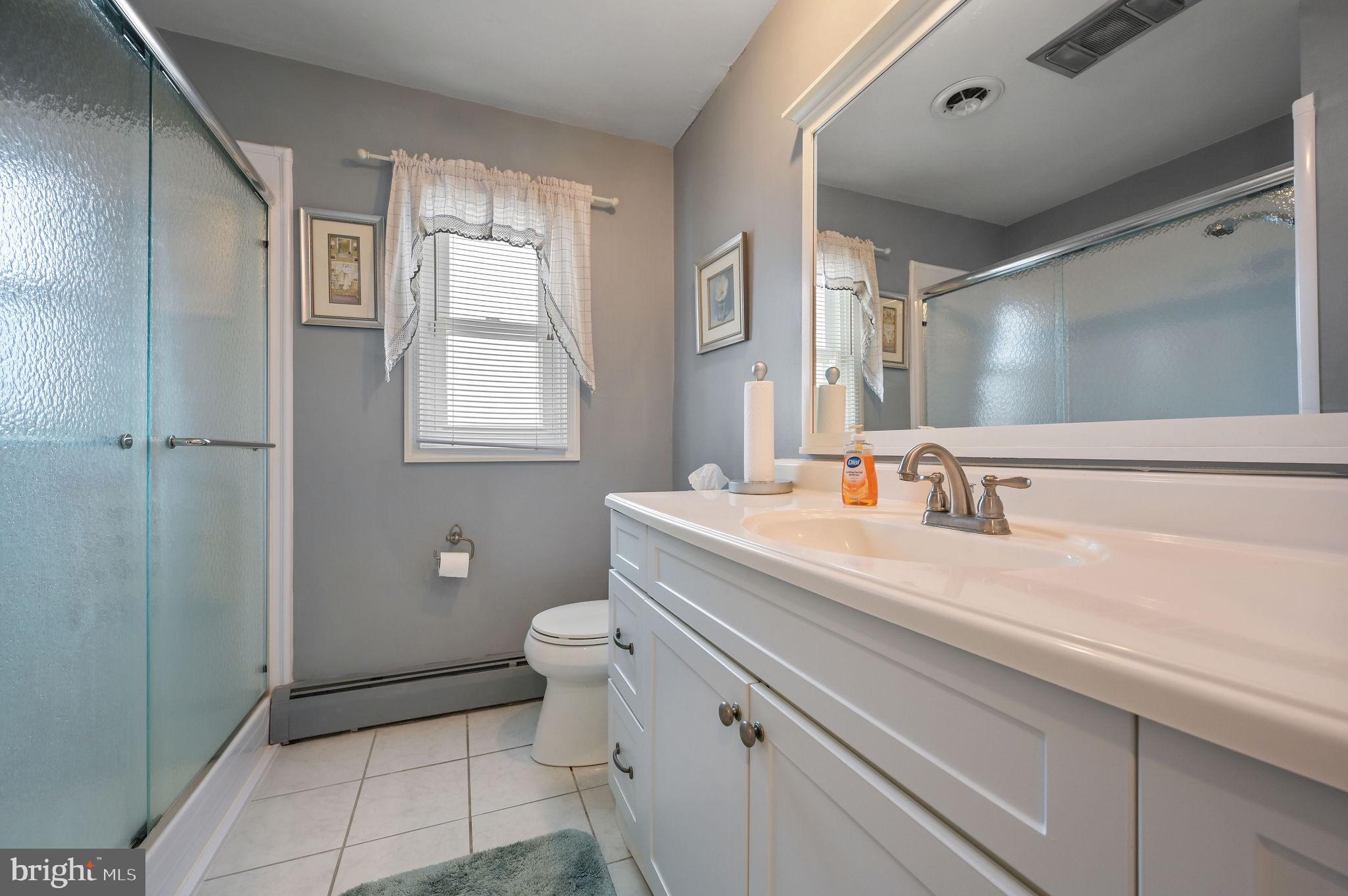 4634 Kenton Road Dover, DE 19904 - Photo 29 of 34 a bathroom with a sink a toilet and a large mirror